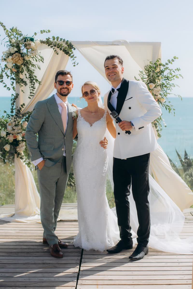 Vova with a newly married couple at their seaside ceremony