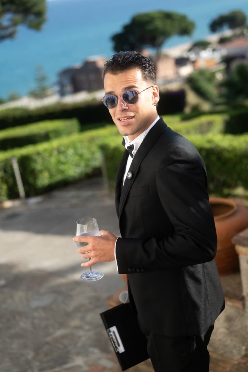 Vova in sunglasses holding his notes and a glass between moments