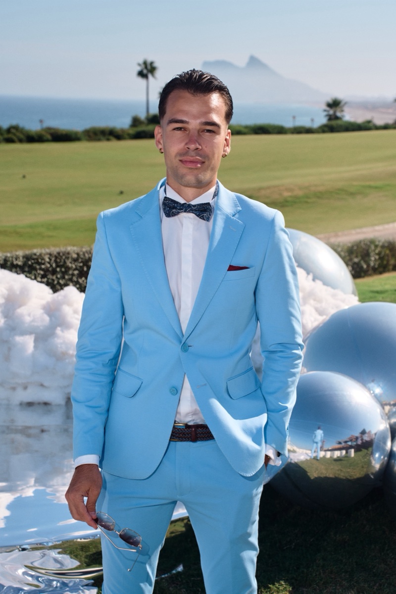 Vova in a blue suit beside the cloud-inspired ceremony setting