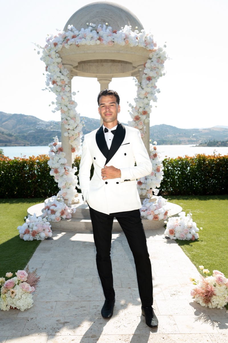 Vova standing beneath the floral ceremony arch overlooking Lake Viñuela