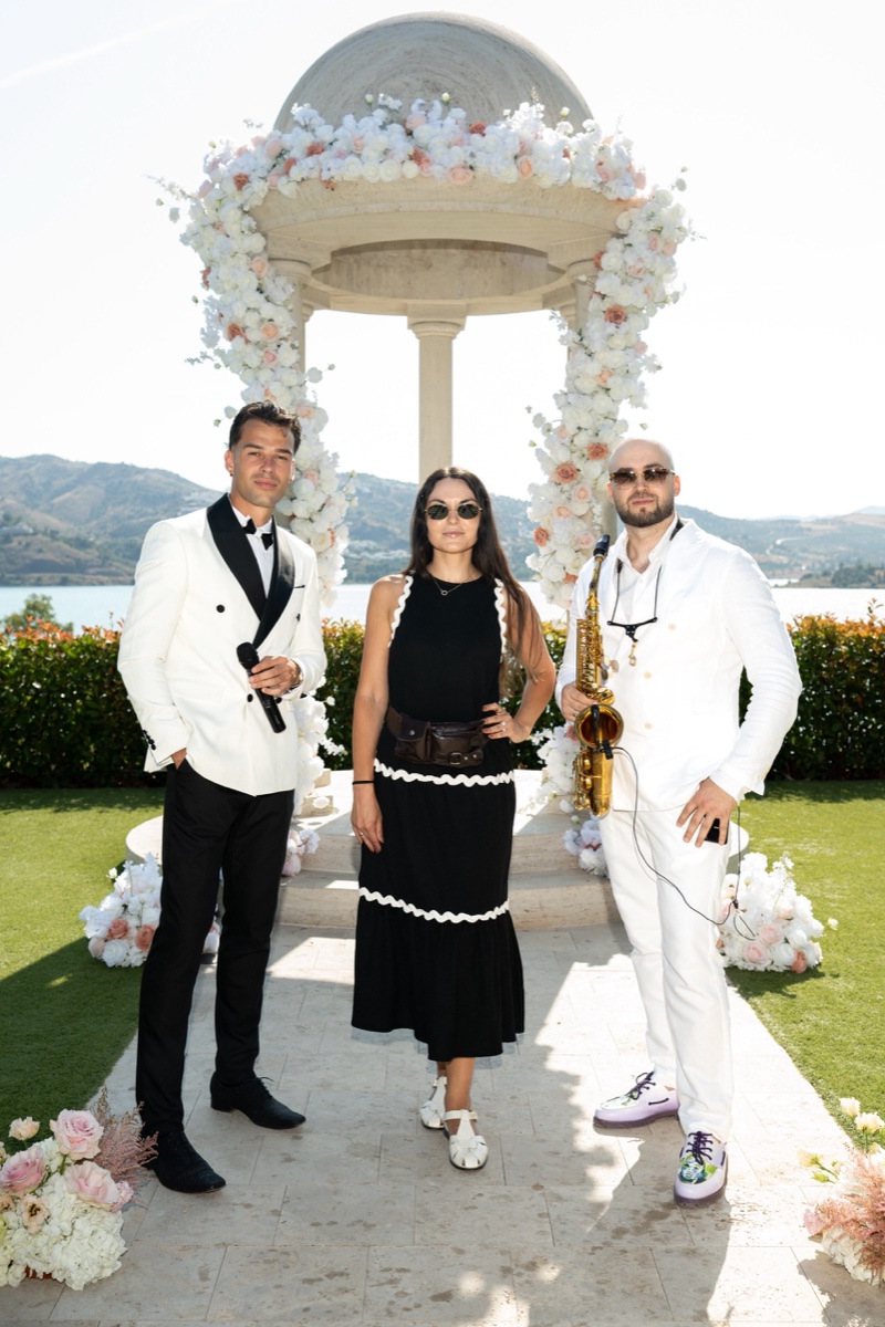Vova with a guest and saxophonist at the lakeside ceremony venue